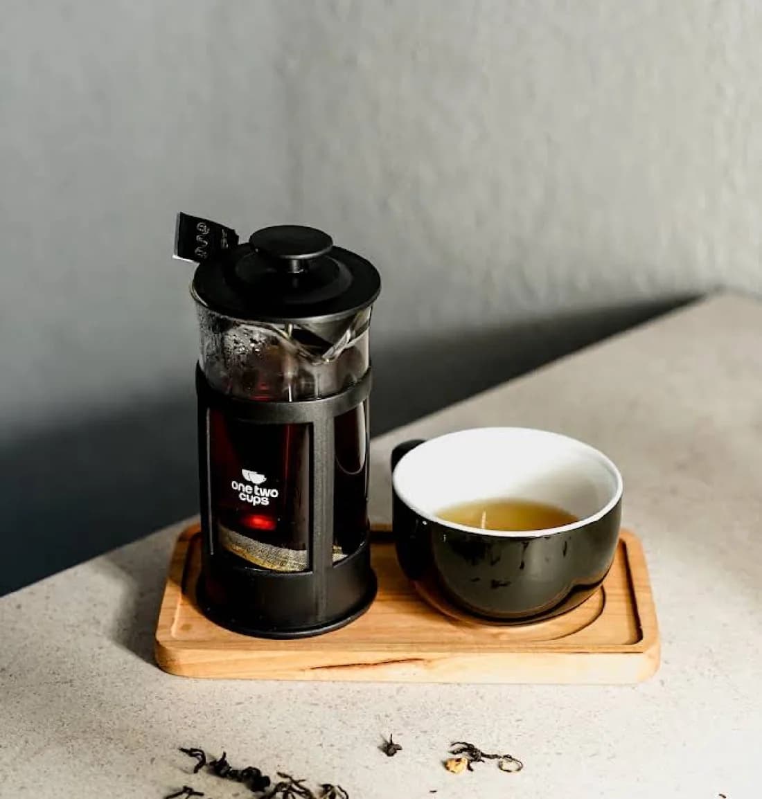 French press dan cangkir di atas nampan kayu