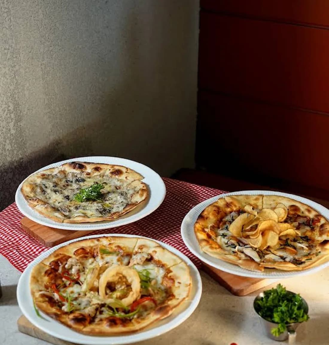 Tiga pizza di atas meja